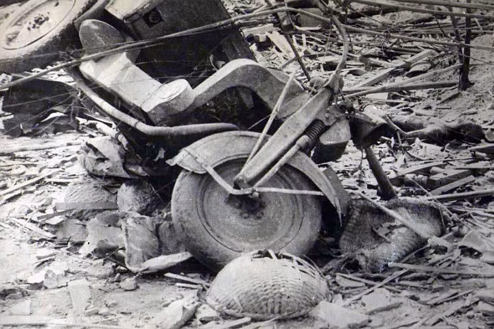Một chiếc xe đổ nghiêng giữa đống đổ nát sau vụ nổ bom nguyên tử.