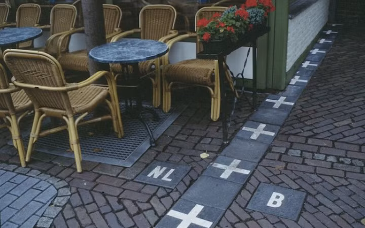 Hà Lan và Bỉ. Đó là cách mà Hà Lan và Bỉ phân chia. Một đường gạch đánh dấu. Bạn có thể thưởng thức một tách cà phê ở phía Hà Lan tại Baarle Nassau Frontier Cafe và sau đó đứng dậy nhả một làn khói thuốc ở bên Bỉ.