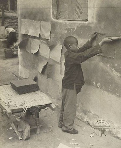Một em bé Trung Quốc đang phơi giấy tại xưởng sản xuất giấy. Ảnh: sina.com.cn.