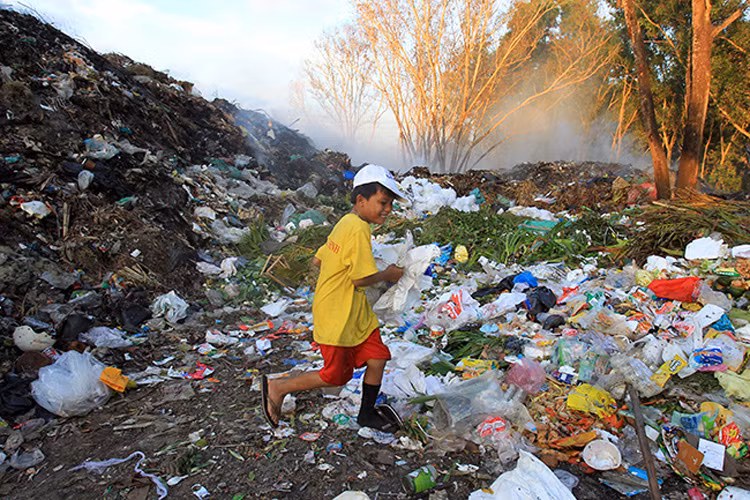 Bé Tuấn là một trong số đó. Sáng đi học, đến chiều, Tuấn lại cùng mẹ ra bãi rác bới phế liệu kiếm sống.
