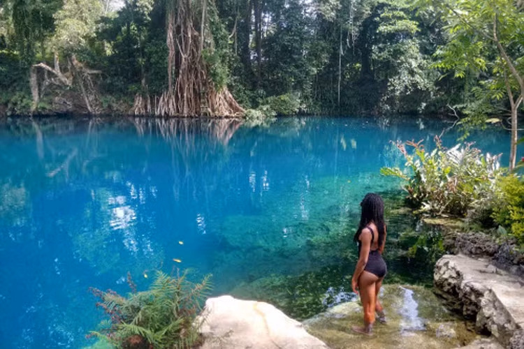 Nữ du khách Nola Ojomu ngắm nhìn vẻ đẹp của nước trong xanh, trước khi nhảy xuống tắm.