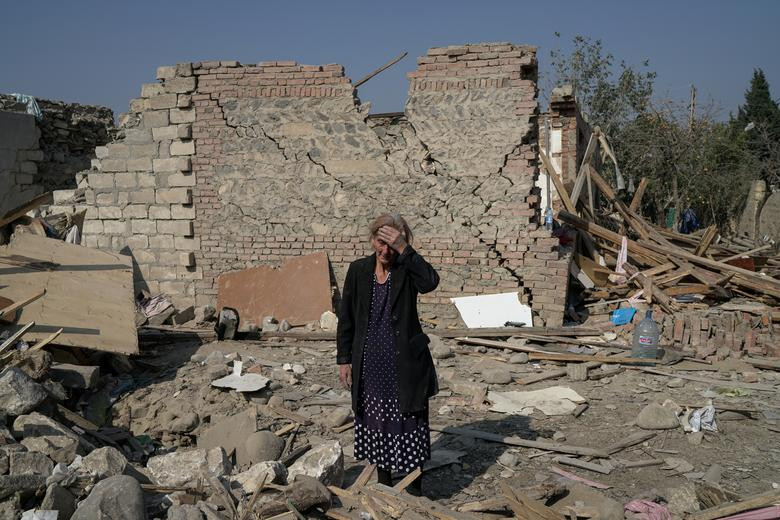 Bà Regibe Guluyeva, 67 tuổi, đứng giữa đống đổ nát của ngôi nhà bị phá hủy do trúng rocket tại thành phố Ganja, Azerbaijan, ngày 18/10.