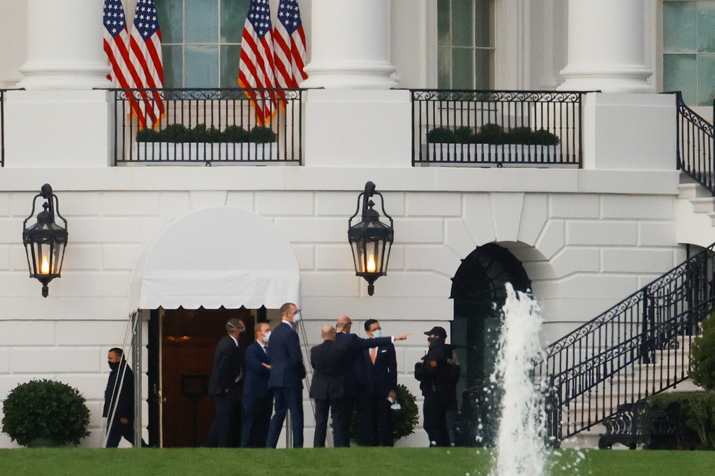 Mật vụ và quan chức Nhà Trắng tụ tập gần nơi tổng thống Mỹ đáp trực thăng. Ảnh: Reuters.