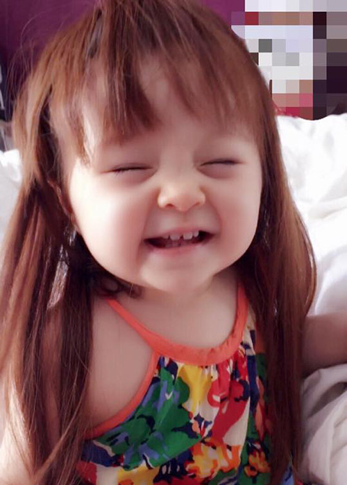 Bé Mộc Trà - con gái hot girl Elly Trần cười tươi khi đội mái tóc giả của mẹ.