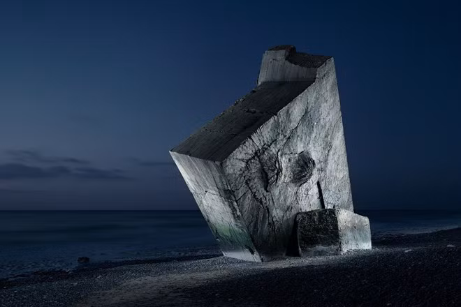 Một phần bức tường còn lại của một boongke trên biển của quân Đức. Dấu vết đạn pháo có thể thấy rõ ở trên tường.