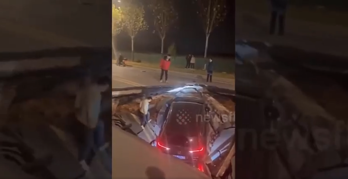 Một hố tử thần khổng lồ đã bất ngờ xuất hiện trên một con đường ở Vũ Hán, Trung Quốc, vào tối 23/11 và "nuốt chửng" nhiều ô tô đang di chuyển. Camera ghi lại cảnh các xe ô tô màu đỏ và đen mắc kẹt dưới đường cao tốc bị sập, với một nạn nhân bị kẹt chân. Hai tài xế khác đã thoát ra khỏi hố. (Ảnh cắt từ clip)