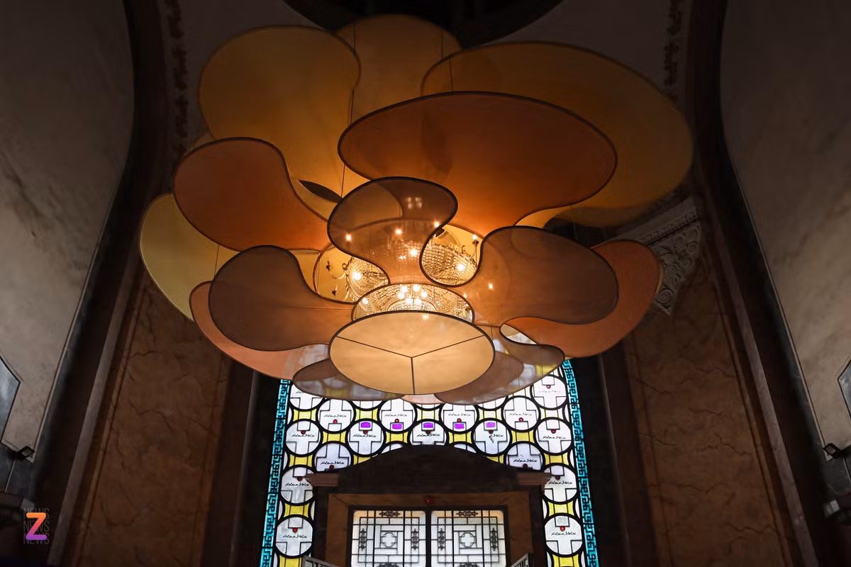 Tại mái vòm cửa chính tòa nhà, tác phẩm Mạch nguồn là thiết kế tương tác ánh sáng của KTS Lê Phước Anh với bộ đèn chùm được treo cao giữa sảnh, hướng sâu lên các tầng cao. Lấy cảm hứng từ các gam màu trầm ở tranh lụa của các họa sĩ thời Đông Dương, Lê Phước Anh đã thiết kế các tấm voan lụa xếp lớp, nhìn thẳng từ dưới lên sẽ thấy như những cánh hoa.