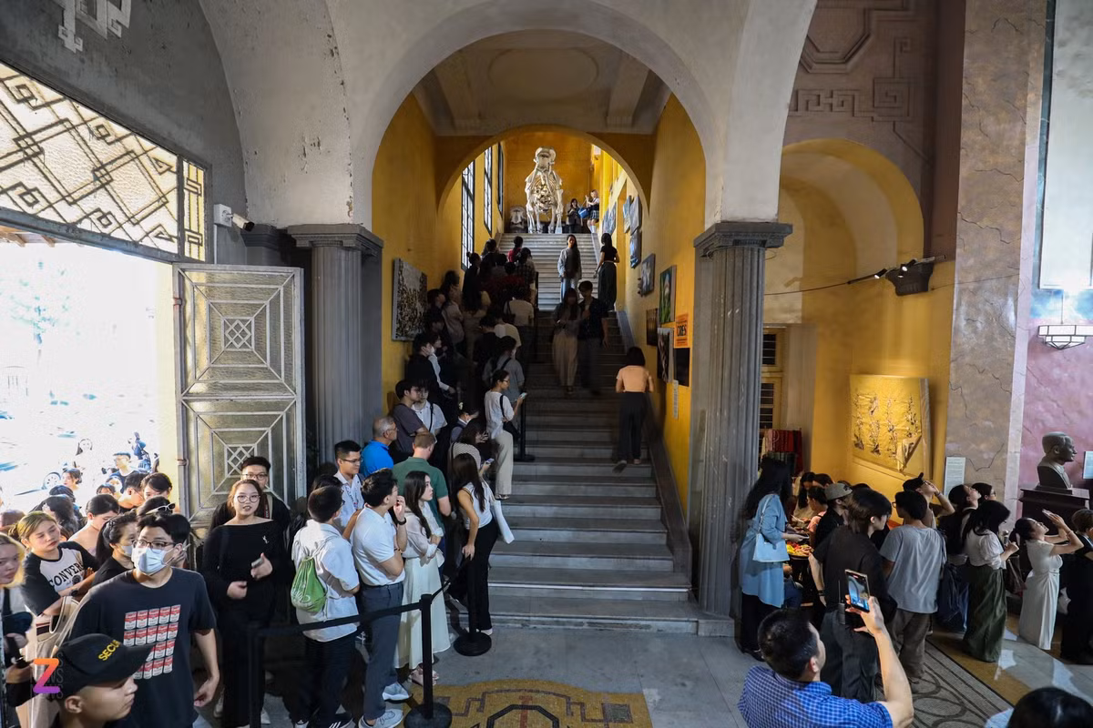 Phía bên kia cầu thang, hàng dài người xếp hàng chờ tới lượt lên tầng 2 tới tầng 5 tham quan các tác phẩm trưng bày tại tòa nhà Đại học Tổng hợp Hà Nội. Để tránh xảy ra tình trạng quá tải, BTC sắp xếp mỗi lượt tham quan có tối đa 15 người với thời lượng 10 phút. Vào những ngày cuối tuần khi lượng khách tăng đột biến, thời gian tham quan mỗi lượt giảm xuống còn 7 phút.