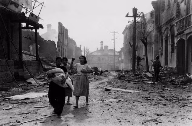 Những người tị nạn đi dọc con phố bị tàn phá ở Incheon, Hàn Quốc, sau một cuộc tấn công của Mỹ ở cảng biển ngày 16/9/1950.