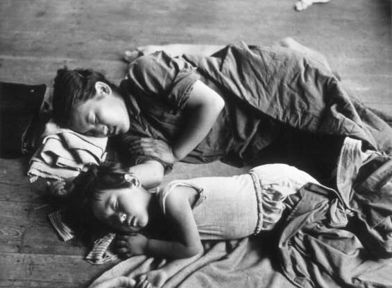 Một phụ nữ Hàn Quốc nằm ngủ bên cạnh con của mình dưới sàn lớp học ở Daejon, Hàn Quốc năm 1950.