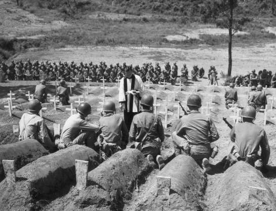 Vị linh mục đang cử hành tang lễ tại một nghĩa trang, nơi chôn cất các binh sỹ Mỹ tử trận, năm 1950.