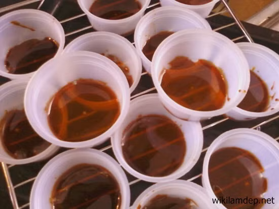 Bước 2: Chuẩn bị những chiếc khuôn bánh hình trái tim, hình tròn hoặc đĩa sâu lòng, múc khoảng 1 thìa nước đường đã đun ở trên đổ vào khuôn bánh. Bạn chỉ cần đổ một lớp mỏng vừa tràn đều đáy khuôn là được.