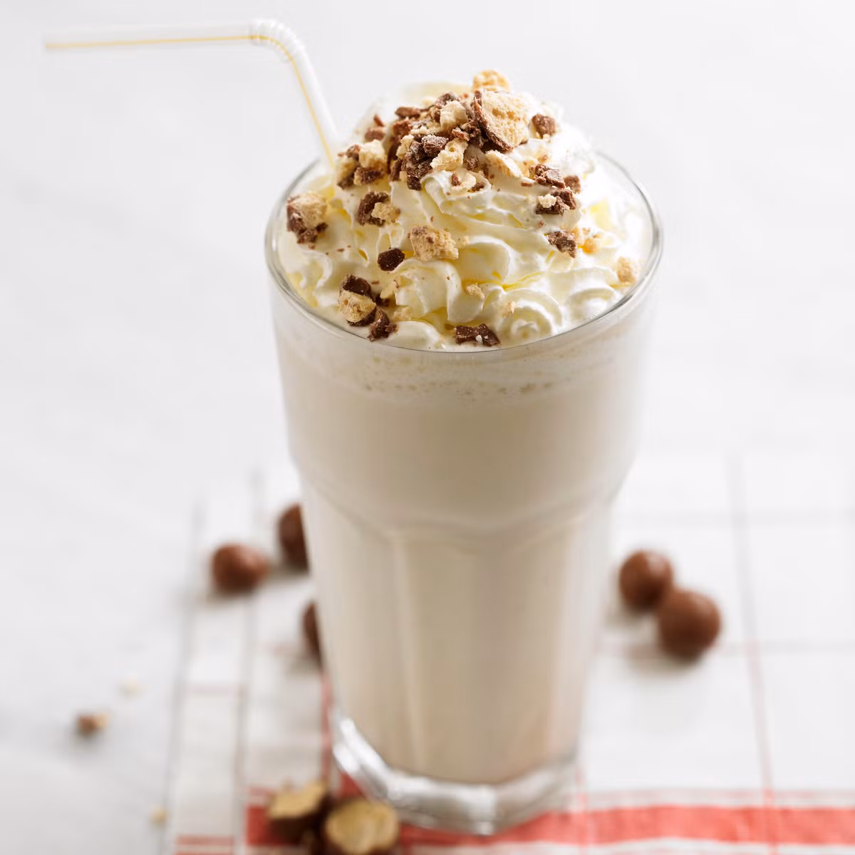 Pha cà phê Milkshake cầu kỳ hơn các loại khác một chút. Bạn cần có 60ml cà phê espresso, 50ml nước cốt dừa, 1 thìa cà phê hạt é. Đầu tiên hãy cho 150ml nước cốt dừa và vani vào nồi đun sôi lăn tăn, tắt bếp để nguội cho vào ngăn đá. Hạt é rửa sơ, cho vào 50ml nước cốt dừa ngâm cho nở.