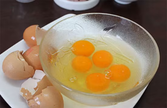 Bước 3: Đây là công đoạn làm bánh flan. Trứng gà đập vỡ và tách riêng lòng trắng, lòng đỏ ra hai bát khác nhau.