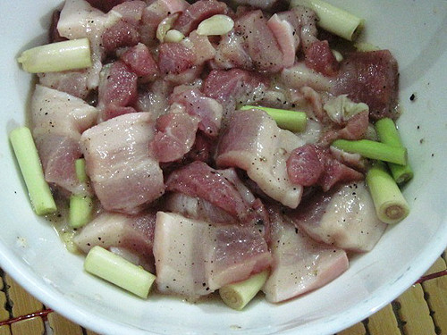 Thịt ba chỉ thái xong cho vào bát ướp với hành tím băm nhuyễn và một muỗng canh nước mắm, 1 muỗng cà phê tiêu trong 30 phút cho thịt thấm gia vị. Hành lá rửa sạch,cắt phần cọng trắng băm nhuyễn. Phần lá hành thái thành khúc khoảng 1,5 đốt tay.