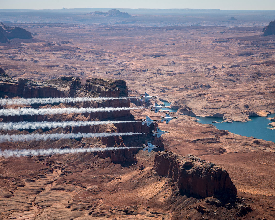 5 chiếc F-16 đang bay đội hình delta. Luồng khói trắng từ máy tạo khói kết hợp với sự hoang sơ trên hồ Powell tạo nên hình ảnh đẹp mắt. Ảnh: USAF.