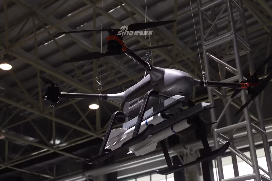 Mẫu UAV này được trang bị 4 động cơ cánh quạt kép. Nó được trưng bày cùng 2 tên lửa dưới bụng. Góc chụp này chưa thể xác định vị trí lắp cảm biến để tìm kiếm và khóa mục tiêu cho tên lửa. Ảnh: Sina.