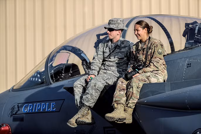 Phút thư giãn của 2 nhân viên hàng không Mỹ trên chiến đấu cơ F-15. Ảnh: TASS.