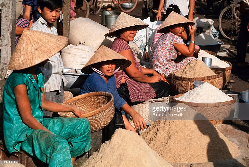 Chợ nông sản ở Tam Nông, Đồng Tháp năm 1993. Hình ảnh nằm trong loạt ảnh Việt Nam thập niên 1990 của Peter Charlesworth.