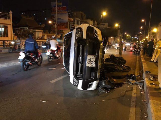 Cú húc kinh hoàng khiến chiếc ô tô lật sang một bên trong khi người đi xe máy bị hất văng xuống đường.