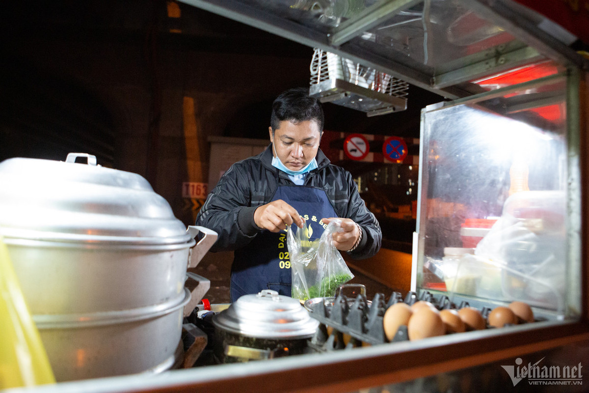 Anh Tính, người bán đồ ăn nóng bằng xe đẩy trên đường Khuất Duy Tiến chia sẻ, tối nay trời lạnh và mưa nên ế ẩm hơn mọi ngày.
