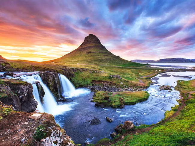 Kirkjufell, Grundarfjörður, Iceland: Kirkjufell có một vị trí độc đáo trên bán đảo Snæfellsnes. Đỉnh núi dường như vươn ra khỏi đại dương, và những thác nước phía trước càng khiến vẻ đẹp của ngọn núi thêm hùng vĩ.