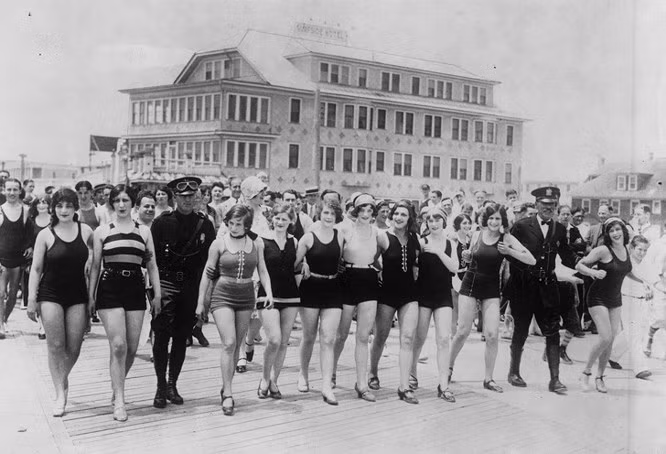  3. Phụ nữ trên bãi biển New Jersey vào năm 1920 vì những bộ đồ bơi “không đứng đắn”: Một thế kỉ trước, luật pháp và lực lượng trật tự không chỉ truy bắt tội phạm mà còn đuổi theo những phụ nữ mặc đồ bơi “không đứng đắn” trên bãi biển. Tuy nhiên nhìn bức ảnh này, có vẻ như những cô gái này không hề sợ cảnh sát. Nhiều người tự hỏi rằng liệu các viên cảnh sát này sẽ cảm thấy thế nào nếu thấy phụ nữ mặc bikini hiện đại?