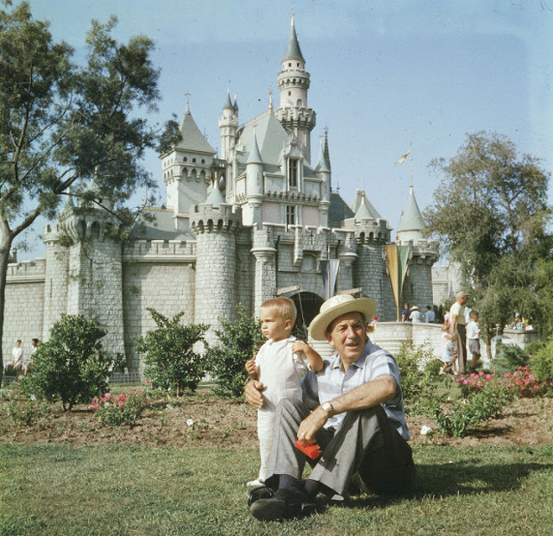 Walt Disney ngồi trên bãi cỏ cùng cháu trai trước Magic Castel ở Disneyland, California, 1955.