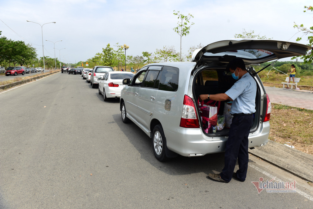"Trong khu cách ly, đội ngũ y tế, lực lượng hậu cận, bảo vệ rất chu đáo. Đồ ăn, nước uống, khẩu trang, nước rửa tay có đầy đủ, đảm bảo dinh dưỡng nên mong người thân đừng lo. Khi đón kiều bào về nước, nhà nước ta đã tính hết các phương án, tạo điều kiện tốt nhất cho người cách ly. Mong các ông bố bà mẹ chỉ nên mang đồ dùng thật sự cần thiết", chiến sỹ công an nhắn nhủ. (Xe ô tô chở đồ tiếp tế xếp hàng dài ngoài đường)