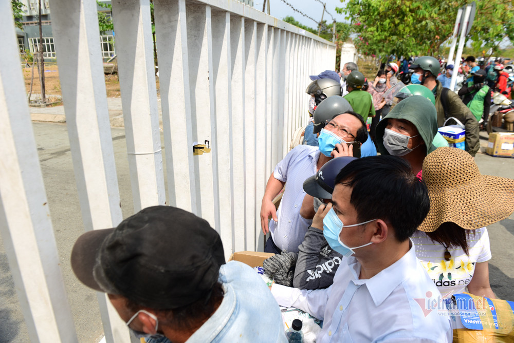 "Một số gia đình muốn con mình được sống đầy đủ, tiện nghi hơn so với trong khu cách ly. Ngoài ra một số bạn trẻ, tuổi mới lớn có những phản ứng, đòi hỏi....Tuy nhiên, khi được động viên, phân tích, các em đều vui vẻ chấp hành các điều kiện của khu cách ly", chiến sĩ công an nói. (Người tiếp tế đứng kín cổng khu cách ly)