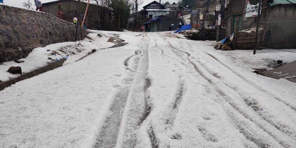 Hình ảnh các hạt mưa đá dày đặc phủ trắng cả tuyến đường.