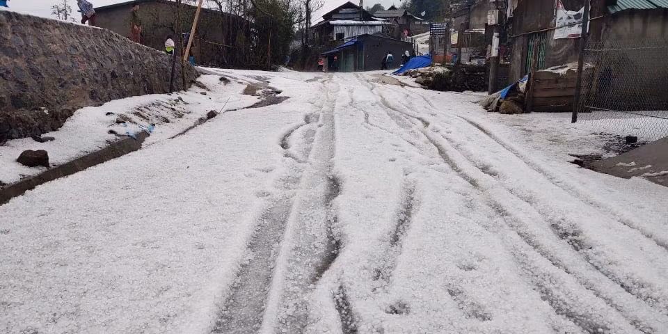 Hình ảnh các hạt mưa đá dày đặc phủ trắng cả tuyến đường.