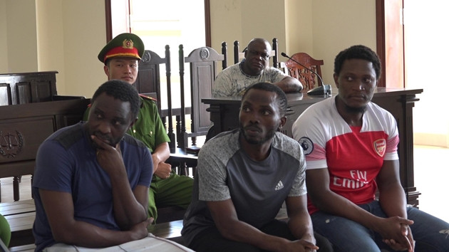 Theo kết quả điều tra ban đầu, bà N.T.D. (trú tại Trần Văn Thời, tỉnh Cà Mau) có quen một người bạn nước ngoài qua mạng xã hội. Sau một thời gian, bà D. có nhận được cuộc gọi điện thoại, xưng là nhân viên hải quan thông báo là có quà từ nước ngoài gửi về. (Các bị cáo (từ trái qua): Nguyễn Hằng Tcheuko Minh, Ifeanyi Matthew Anthony, Monthe De Fouda Paul Martial. Ảnh: Baovephapluat)