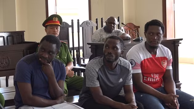 Theo kết quả điều tra ban đầu, bà N.T.D. (trú tại Trần Văn Thời, tỉnh Cà Mau) có quen một người bạn nước ngoài qua mạng xã hội. Sau một thời gian, bà D. có nhận được cuộc gọi điện thoại, xưng là nhân viên hải quan thông báo là có quà từ nước ngoài gửi về. (Các bị cáo (từ trái qua): Nguyễn Hằng Tcheuko Minh, Ifeanyi Matthew Anthony, Monthe De Fouda Paul Martial. Ảnh: Baovephapluat)