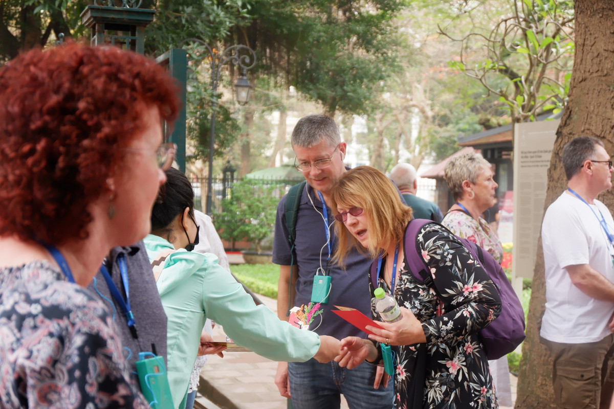 Du khách không đeo khẩu trang vô tư nói chuyện với người bán hàng rong.