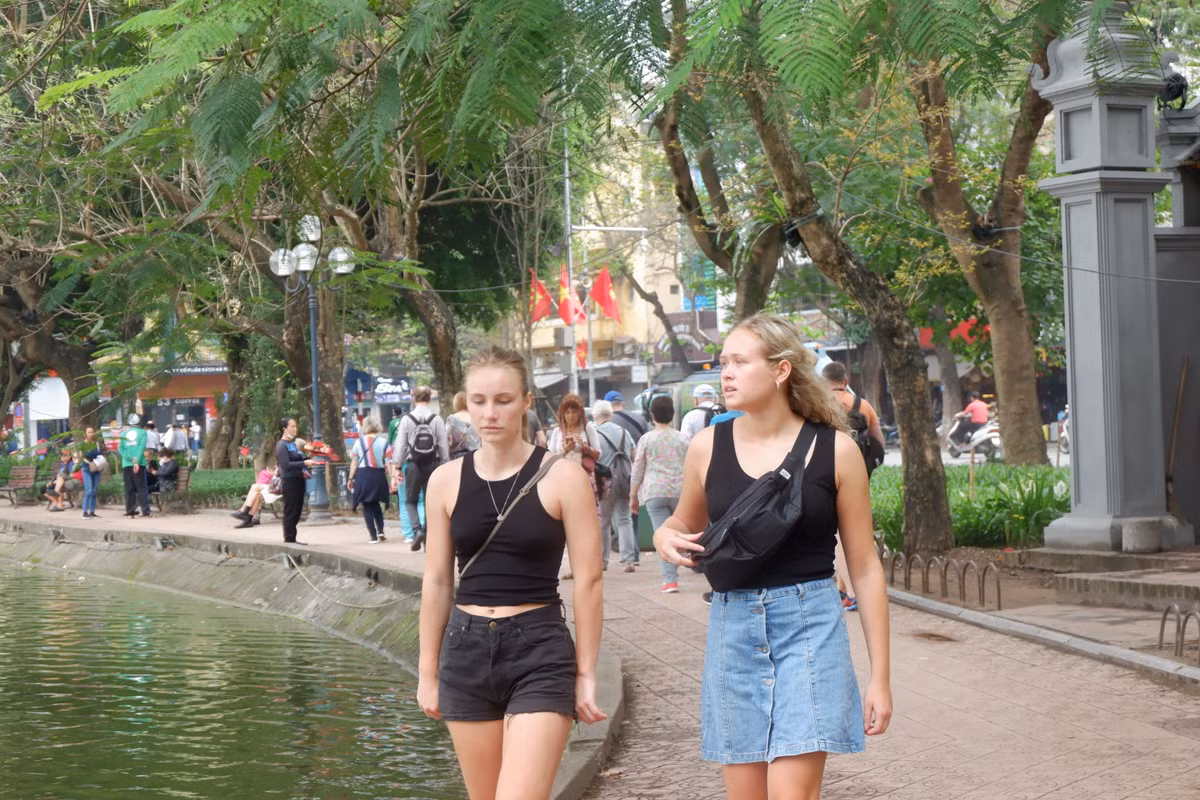 2 nữ du khách nước ngoài không đeo khẩu trang dạo bộ quanh hồ Gươm.