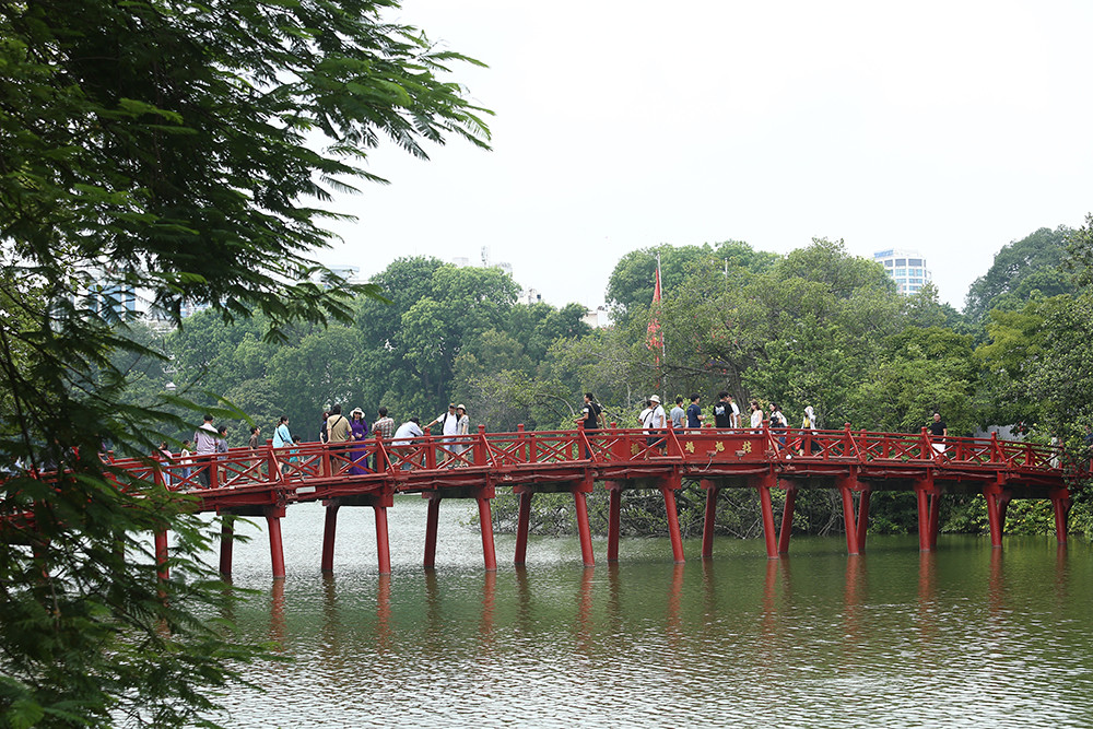 Cầu Thê Húc với sắc đỏ đặc trưng, nằm nổi bật giữa hồ Hoàn Kiếm nối với đền Ngọc Sơn. Nhờ sở hữu thiết kế độc đáo nên du khách rất thích đến đây để chụp ảnh. (Ảnh Đại Đoàn Kết) 
