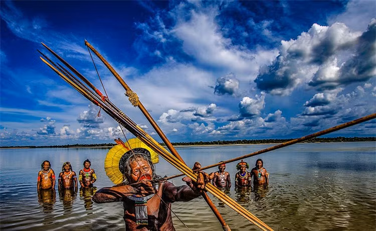 Những thổ dân này tham gia dự án quản lý bền vững, trồng cây gây rừng và chống lại những kẻ từ bên ngoài muốn phá rừng. Năm 2020 ghi nhận hỏa hoạn nghiêm trọng tại Amazon khiến cuộc sống của nhiều bộ lạc thổ dân phải đối mặt với rủi ro bởi đất đai là nền tảng sinh tồn của họ. Một thủ lĩnh bộ lạc bắt cá bằng cung tên. Ảnh: Daily Mail