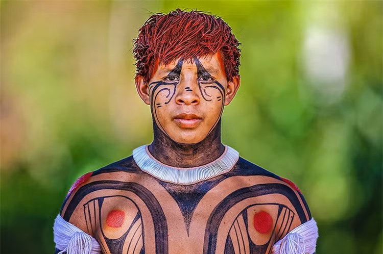 Nhiếp ảnh gia Ricardo khẳng định: “Chúng ta cần cho thấy tầm quan trọng của các thổ dân đối với thế giới, họ bảo vệ rừng của chúng ta. Tôi đến đó để ghi lại tư liệu về những con người đã gặp nhiều khó khăn để bảo vệ thiên nhiên”. Ảnh: Người thổ dân Kalapalo với những hình vẽ ấn tượng trên người và trên khuôn mặt. Ảnh: Daily Mail