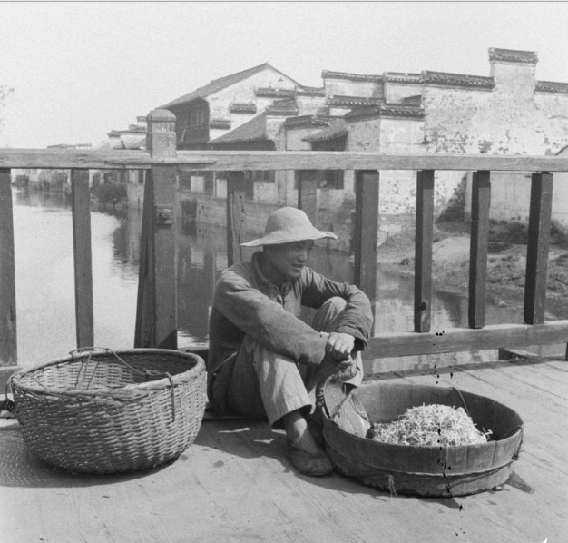 Những gánh hàng rong nghèo mưu sinh trên phố cũng là hình ảnh quen thuộc không thể thiếu của bộ mặt phố phường Trung Quốc thời Dân quốc. Trong ảnh, một gánh hàng bán giá đỗ dừng chân nghỉ trên cầu.