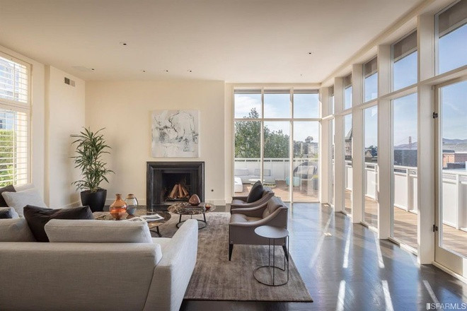 Phòng khách rộng rãi, mang tông màu be chủ đạo để làm nổi bật vẻ đẹp sang trọng. Các bức tường kính bao quanh đem đến nguồn ánh sáng tự nhiên và cảnh sắc thành phố.