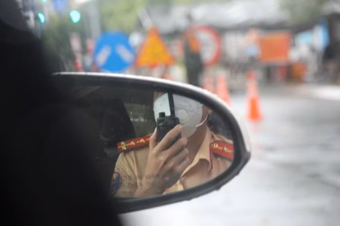 Chiến sĩ CSGT thông báo người dân nhường đường xe ưu tiên. Ảnh: TS