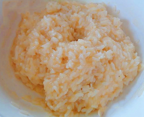 Cách làm pizza cơm nguội như sau: Bước 1: Cho trứng gà và một chút muối vào tô cơm nguội, trộn đều lên trước.