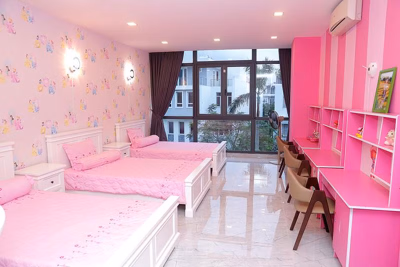 Phòng ngủ của 3 cô con gái mang tông hồng ngọt ngào. Các bé được bố mẹ sắm giường, bàn học và tất cả vật dụng giống hệt nhau.