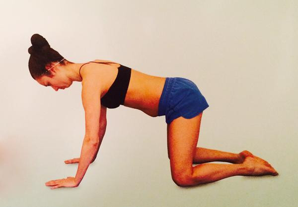 Mẹ quỳ gối và chống hai tay thẳng đứng.