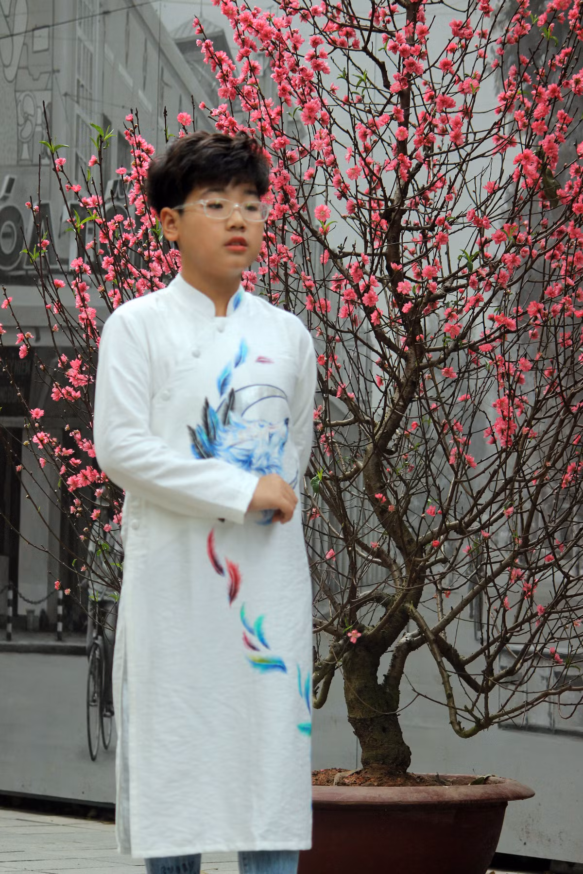 Cả những bé trai cũng mặc áo dài tạo dáng bên những gốc đào được bày biện sẵn trên phố bích họa Phùng Hưng.