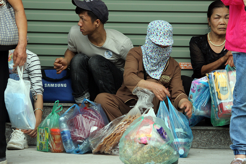 Người dân đến trẩy hội chùa Hương mang theo nhiều đồ đạc lỉnh kỉnh, ngồi vật vờ khắp vỉa hè do quá mệt mỏi bởi thời tiết Hà Nội trong mấy ngày Tết nắng nóng, oi bức.