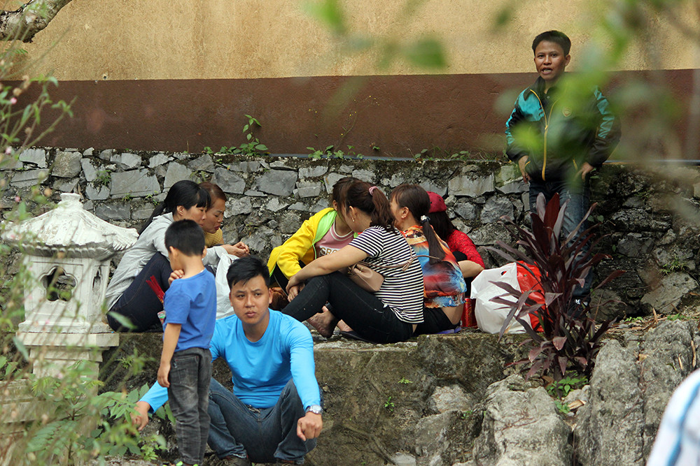 Du khách ngồi túm tụm để ăn uống, nói chuyện trong khuôn viên chùa Hương rất phản cảm.