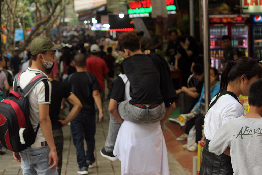 Nam thanh niên phải nhờ bạn của mình cõng trên lưng vì không thể di chuyển kịp mọi người trong đoàn.