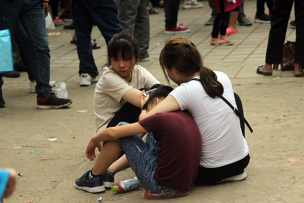 Bé trai quá mệt đành phải ngồi dựa mình vào người chị để tranh thủ chợp mắt ngủ.